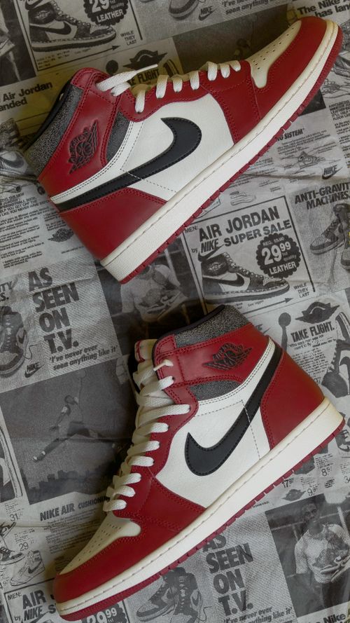 Free Stylish red and white high-top sneakers placed on vintage newspaper for a nostalgic vibe. Stock Photo