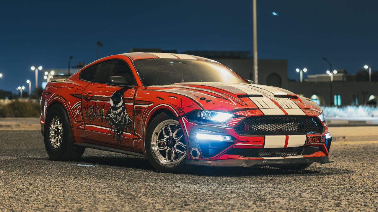 custom ford mustang showcasing a striking red livery parked in an urba