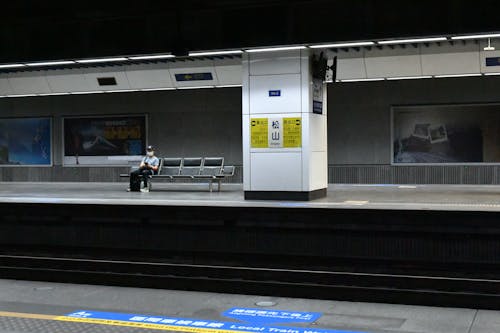 A Person Sitting on a Bench in a Subway Station 