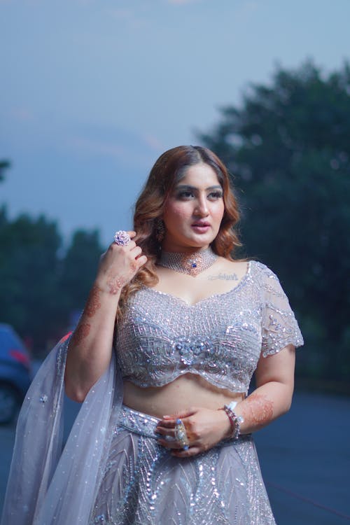 Young Woman in a Sparkly Dress Posing Outside 