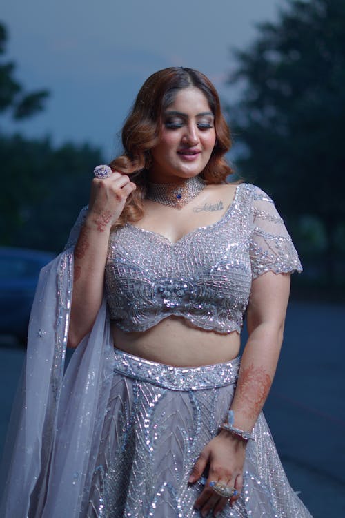 Young Woman in a Sparkly Dress Posing Outside 