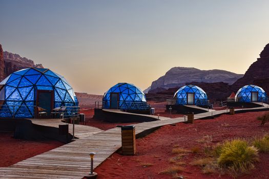 Luxurious geodesic dome tents in the scenic Wadi Rum desert landscape.