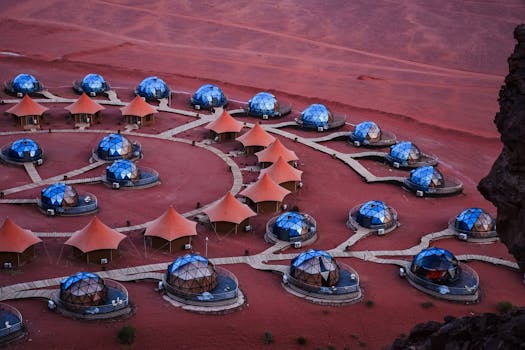 Aerial shot of unique geodesic domes and tents in Wadi Rum desert, Jordan, showcasing luxury glamping.