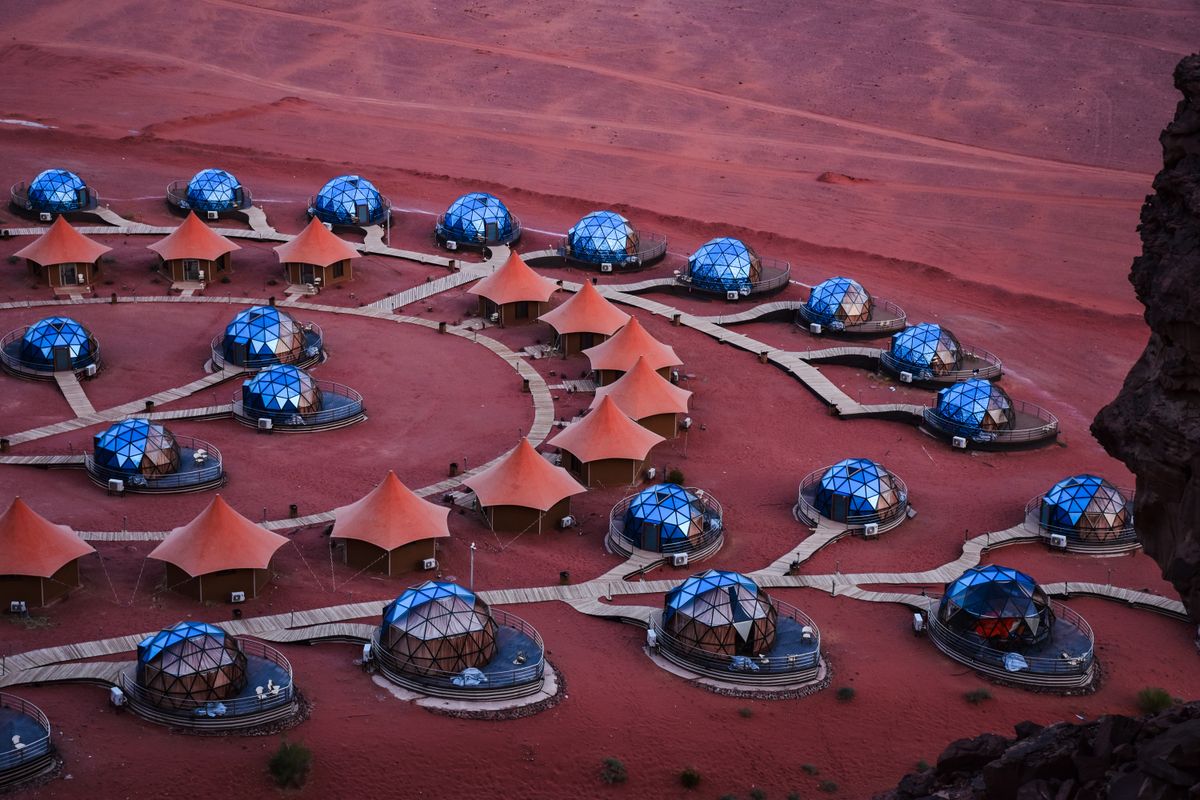 A luxury bubble camp in Wadi Rum, seen from above — transparent domes that let the desert night sky in.