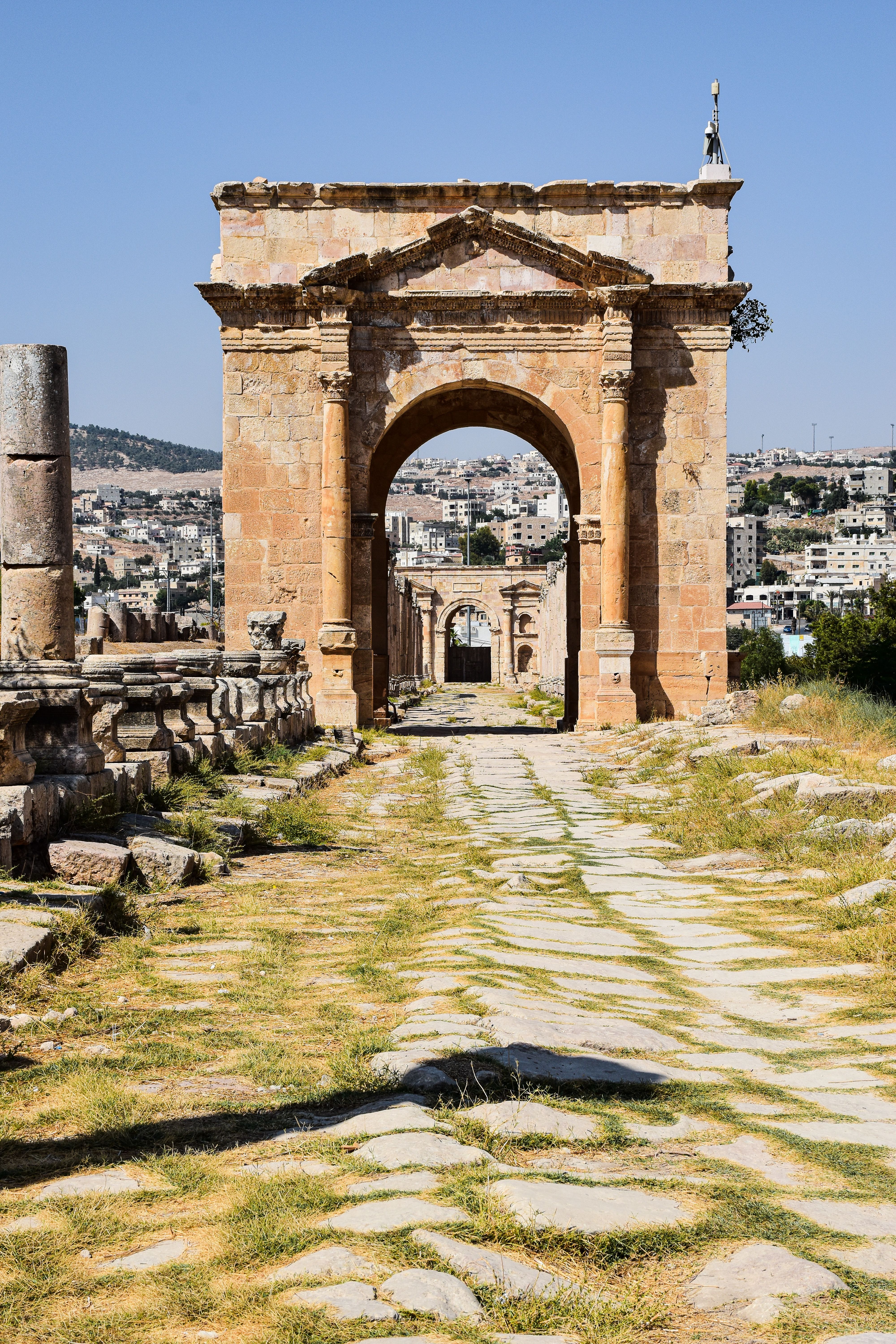 Explore the historic Roman ruins of Jerash with its stunning ancient arch and cobbled road.