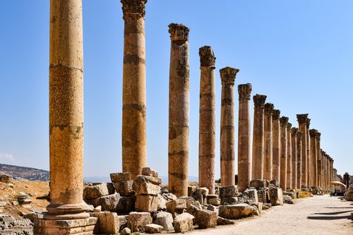 Free Magnificent columns of the ancient Jerash ruins under a clear blue sky, showcasing historical architecture. Stock Photo