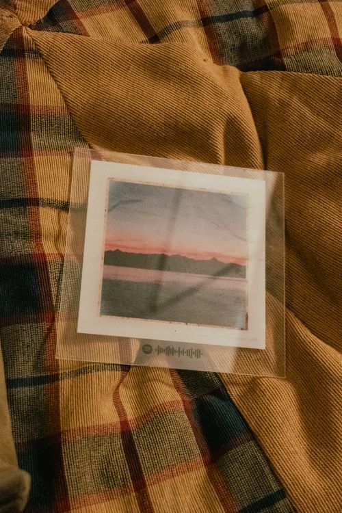 Free Artistic print on a plaid fabric surface, featuring a serene landscape view. Stock Photo