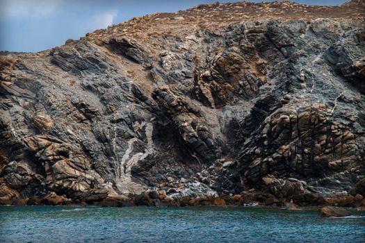 Majestic rocky coastline in Delos, Greece with clear blue water. Perfect for nature and travel themes.
