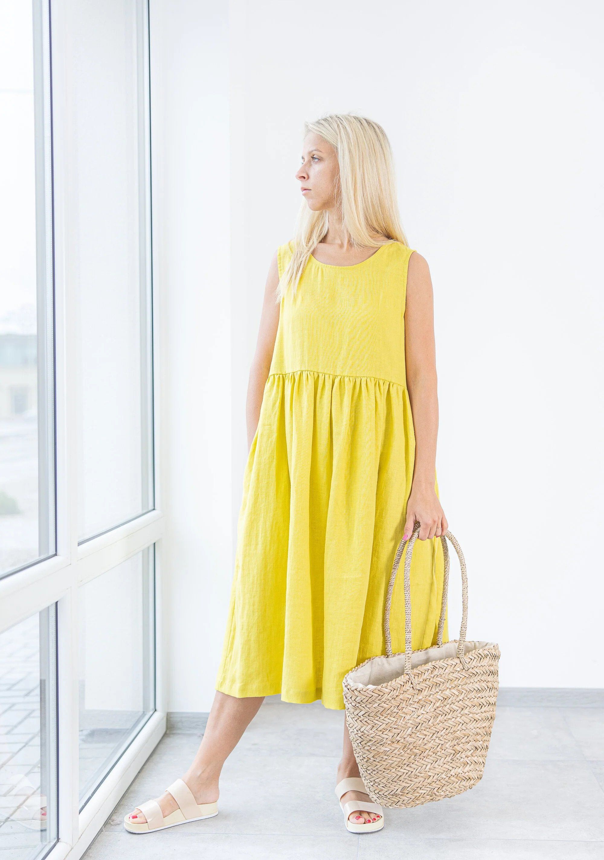 Model in Yellow Sleeveless Midi Dress with a Straw Shopping Bag in ...