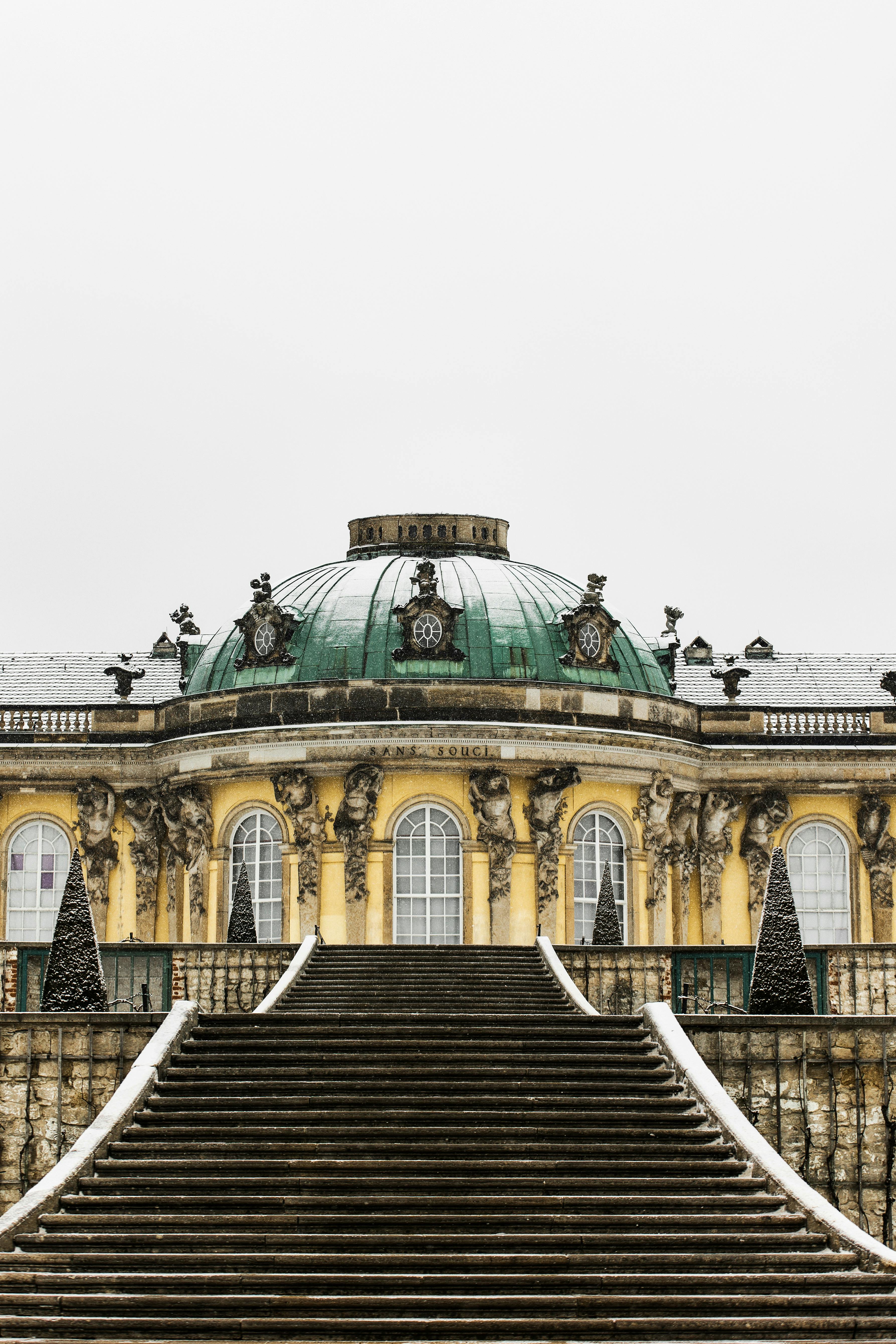 Explore the majestic Sanssouci Palace covered in snow, showcasing its baroque architecture.