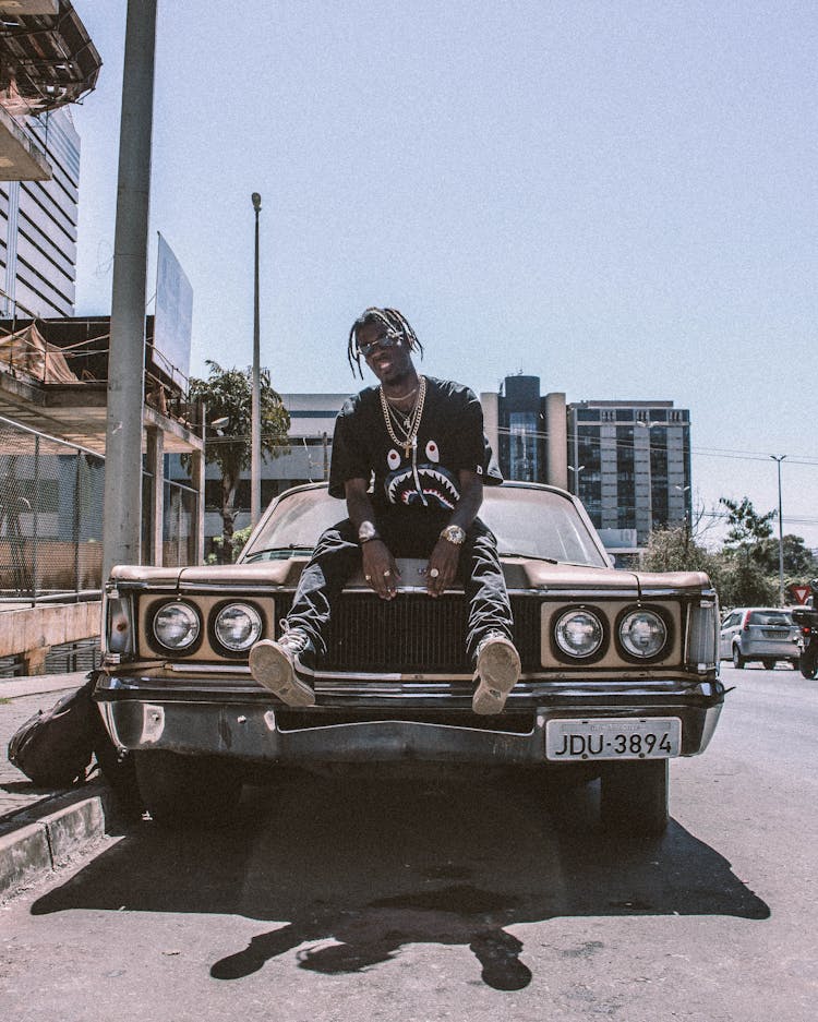 Photo Of Man Sitting On Car Hood