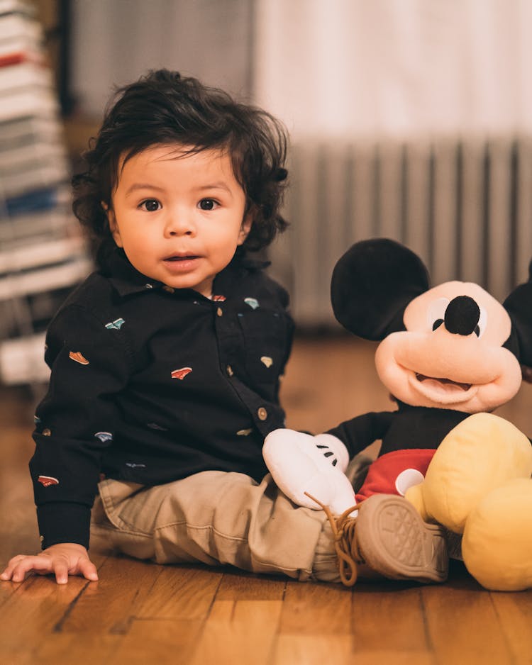 Sitting Child Playing Mickey Mouse Plush Toy