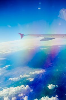 Vibrant aerial view showcasing wing and fluffy clouds from an airplane.