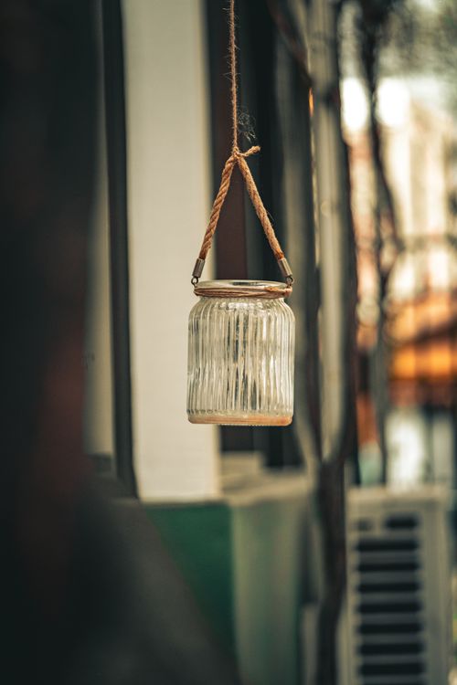 Free A rustic glass jar suspended by a rope, creating a vintage charm outdoors. Stock Photo