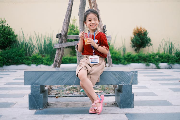 Schoolgirl Eating Her Food On The Bench 