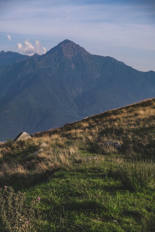 Free Beautiful mountain range with foreground meadow under a clear sky, showcasing serene natural beauty. Stock Photo