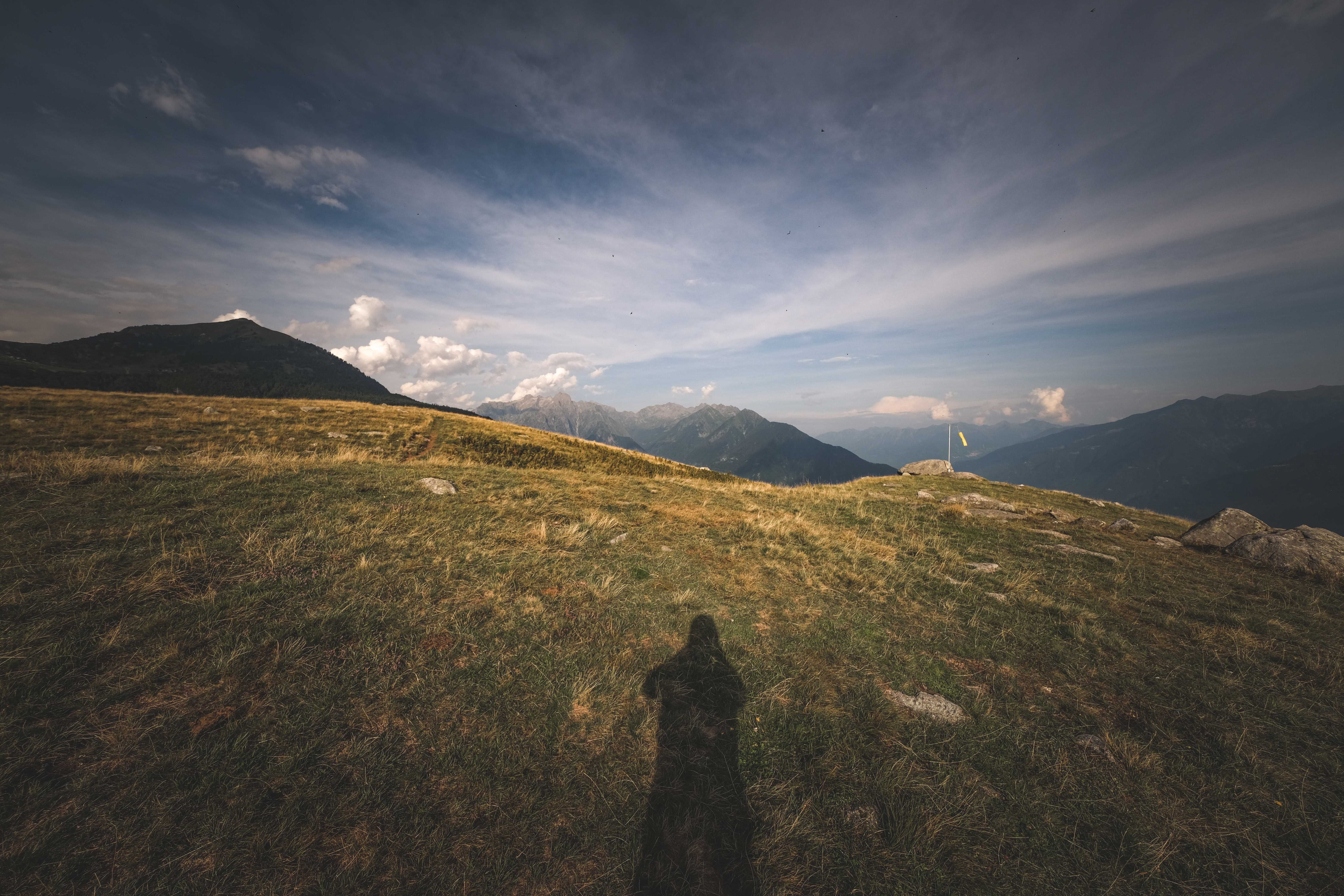 Shadow of a Photographer on the Hill with a View of Mountains in the ...