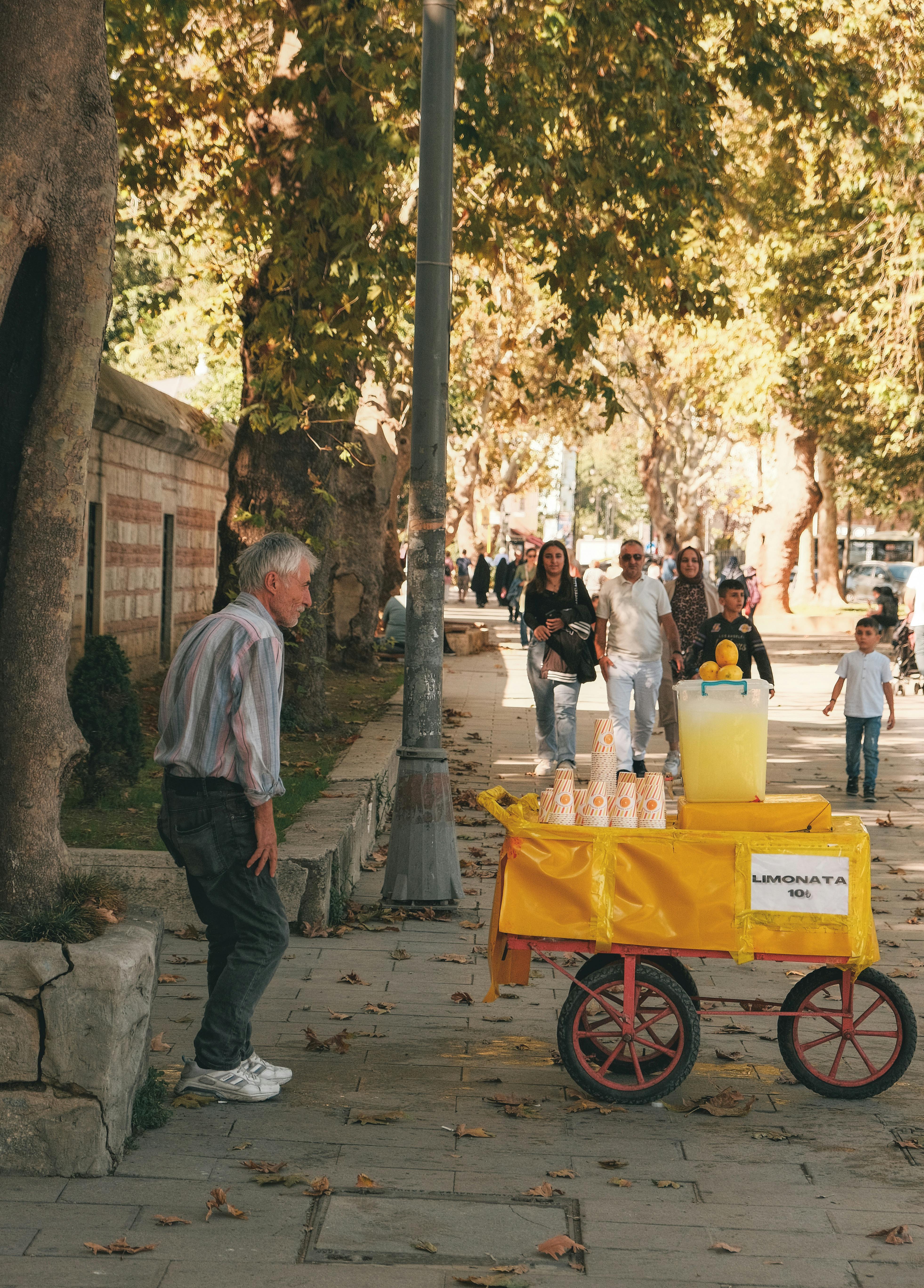 A bustling street in Istanbul with a lemonade stand and pedestrians enjoying a sunny day.
