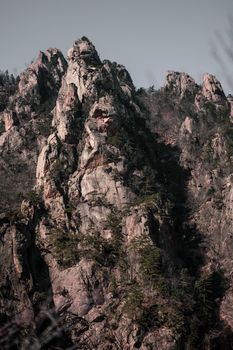 Breathtaking view of rugged rock formations and lush greenery on a mountain landscape.