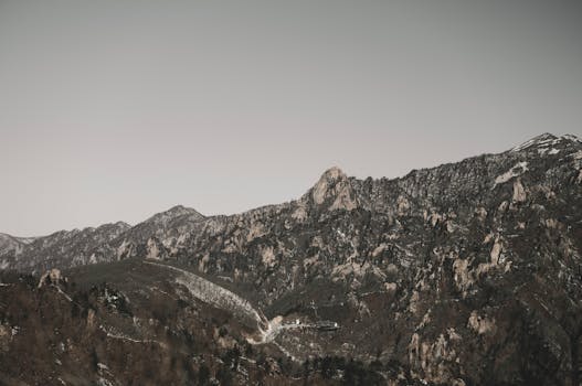 Majestic snow-capped mountain range with rugged terrain and clear winter sky.