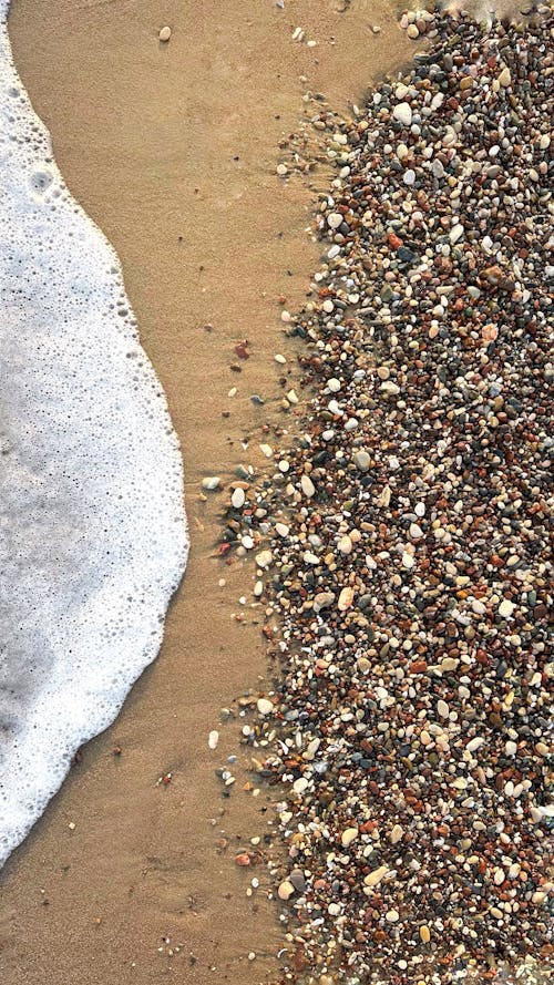 Water Foam and Pebbles on Shore