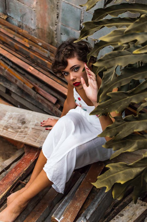 Ücretsiz Kereste üzerinde Otururken Elbise Giyen Kadın Stok Fotoğraflar