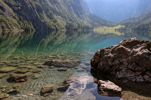 Free Tranquil view of Lake Königssee surrounded by rocky mountains and clear skies. Stock Photo