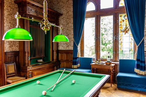 Free An elegant vintage billiard room with classic green felt table and stylish decor. Stock Photo