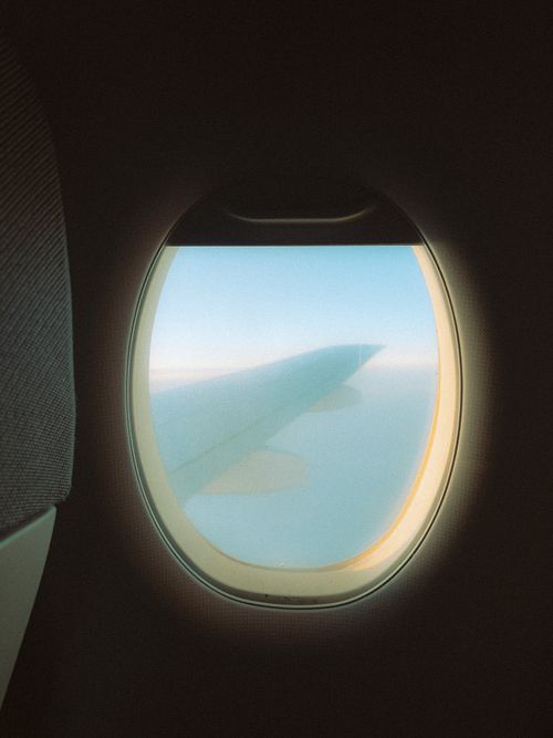 Free View of airplane wing and sky through a window, perfect for travel themes. Stock Photo