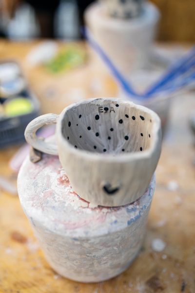 Close-up of a handmade ceramic cup with dark speckled interior — photo by Esma Atak on Pexels