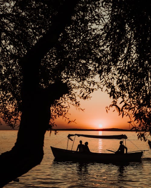 Silhouettes of People on a Boat Admiring the Sunset