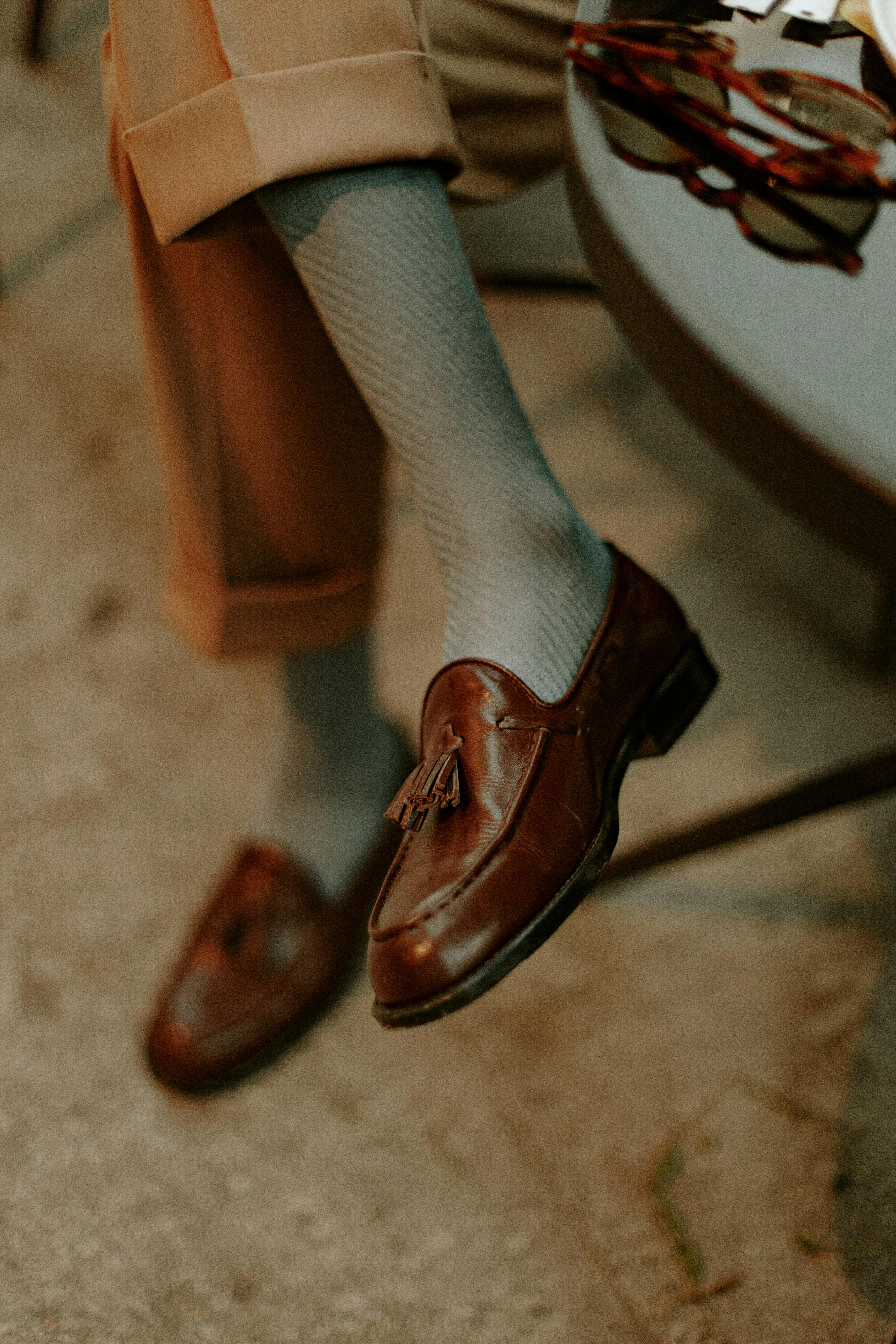 Close-up of elegant brown loafers paired with knee socks, showcasing stylish footwear fashion.