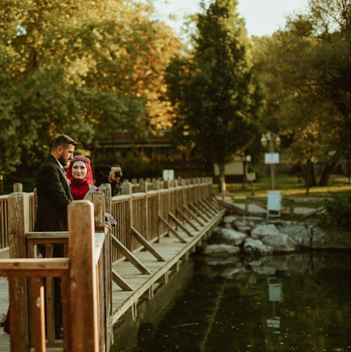 Newlyweds Standing on Footbridge in Park