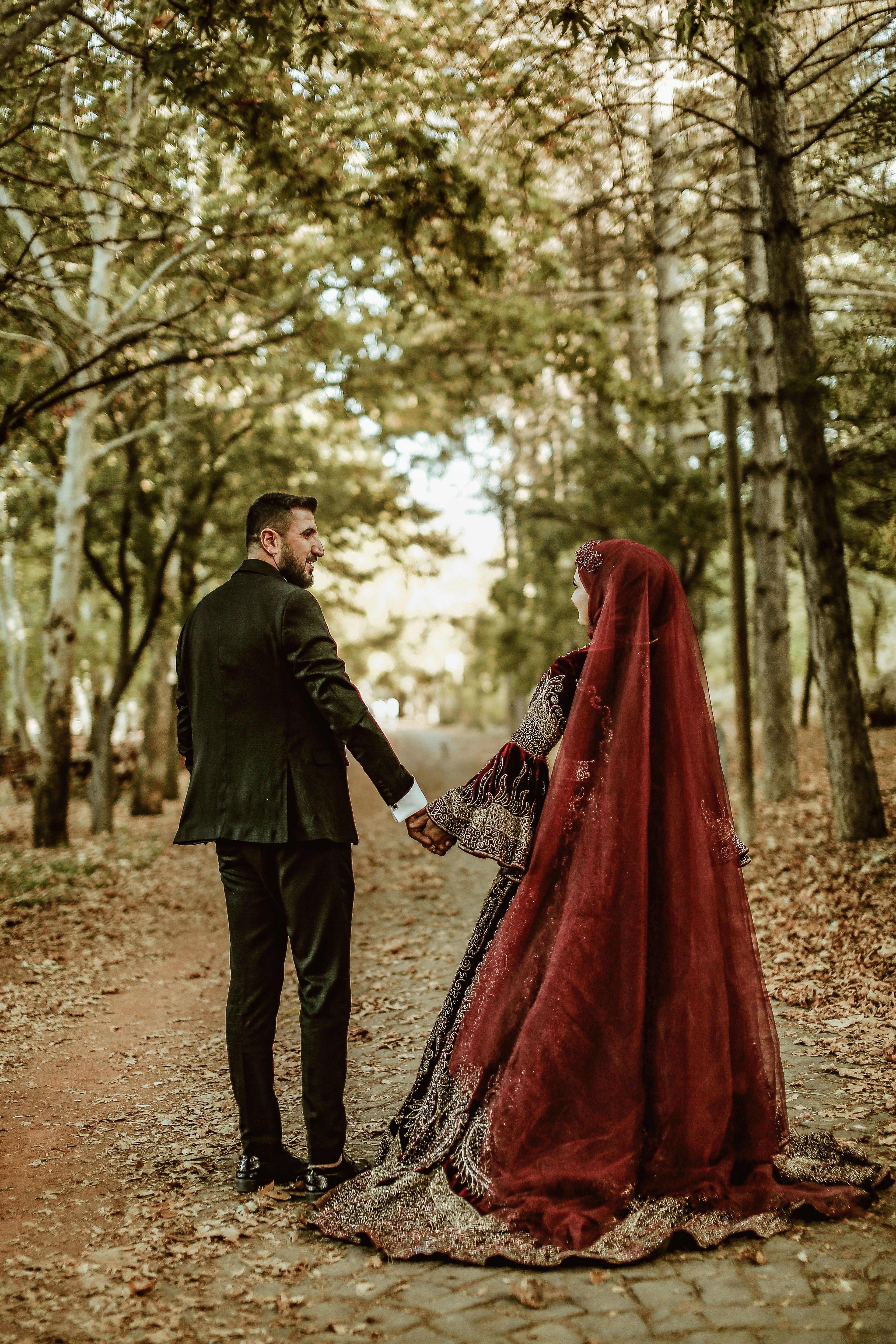 Bride and Groom Holding Hands and Standing in the Forest · Free Stock Photo