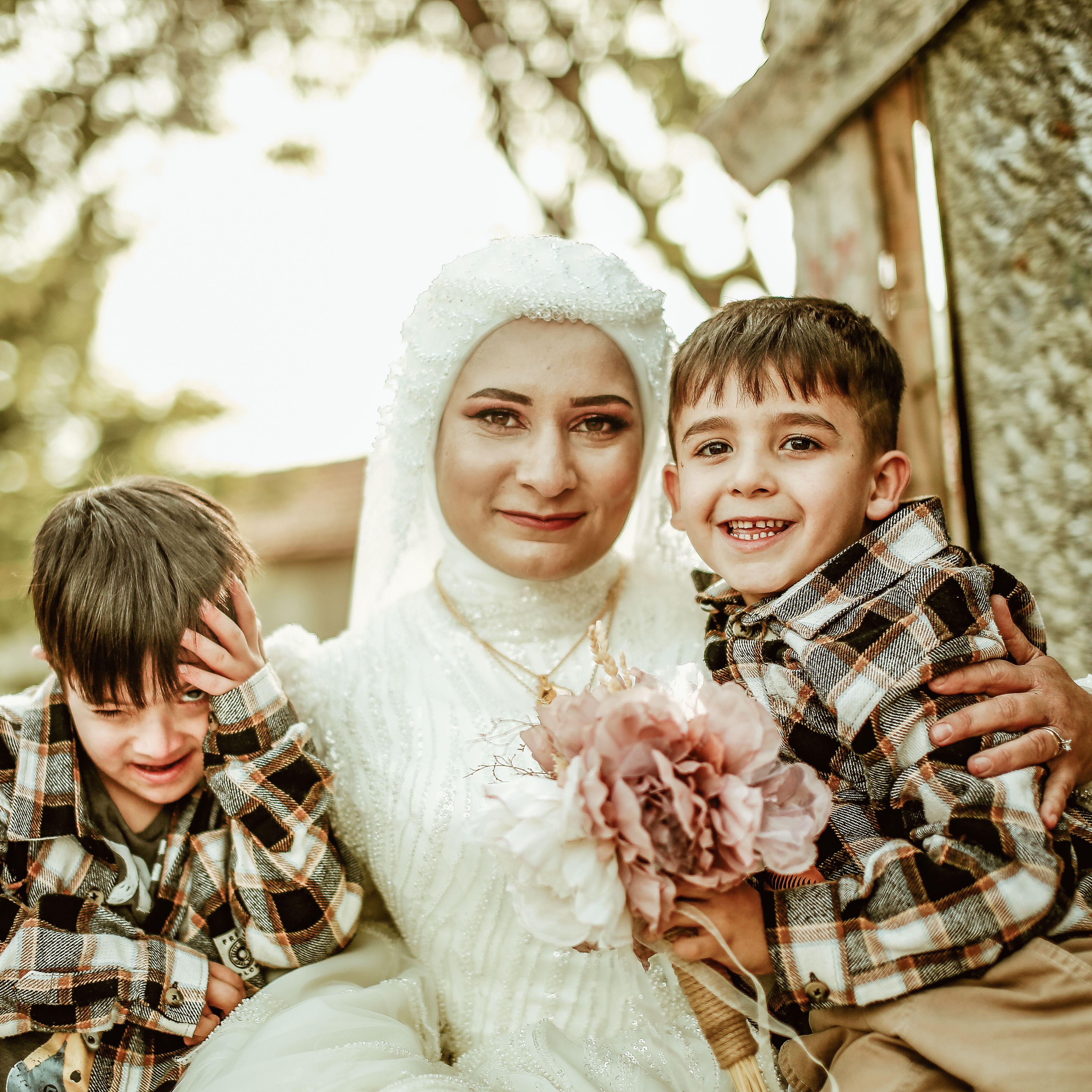 A mother in traditional attire bonding with her sons outdoors, capturing a joyful family moment.