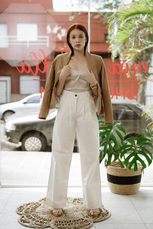 Female Model Wearing White Pants and a Brown Jacket