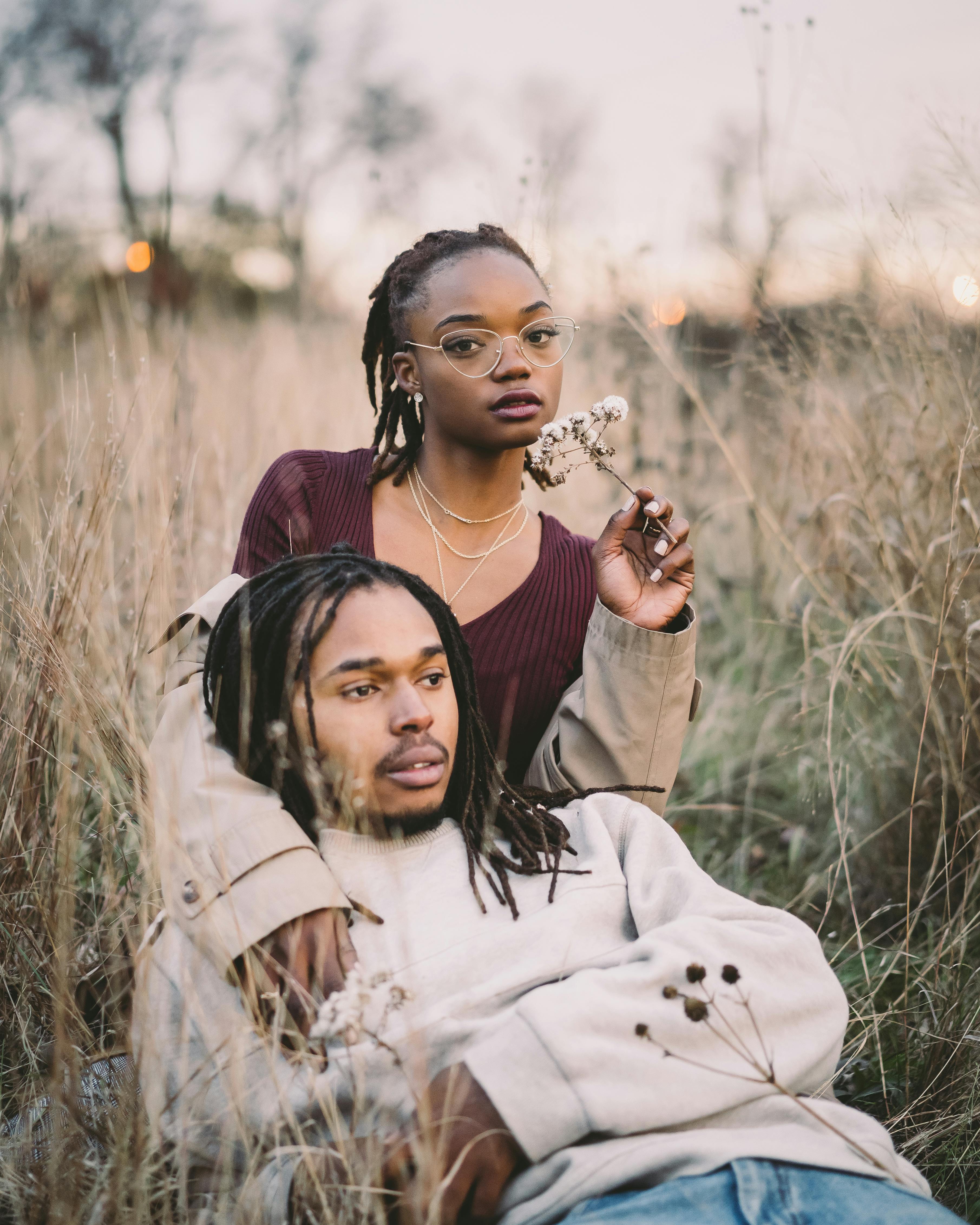 一对时尚的夫妇在郁郁葱葱的草地上享受宁静时刻，展现了团结与自然之美