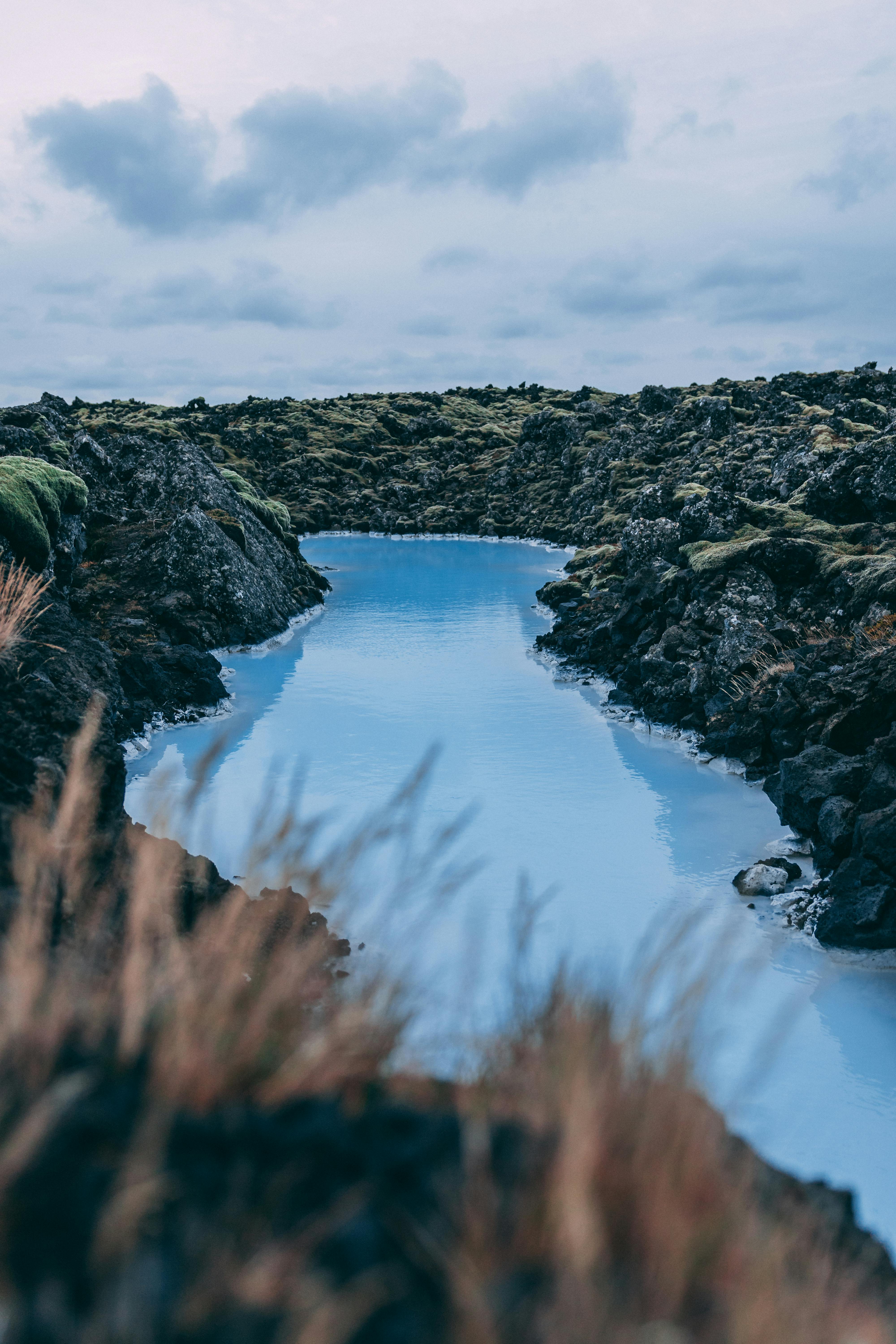 在冰岛，蓝色的地热流穿过苔藓覆盖的熔岩田