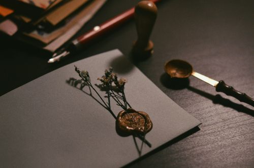 Free A vintage letter with wax seal and flowers on a desk, evoking nostalgia. Stock Photo