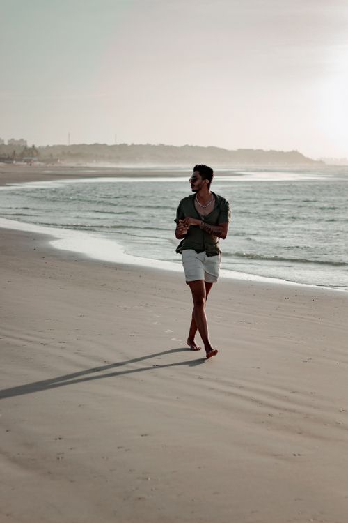 Free A man strolls along the serene beach at sunrise in Brasília, enjoying the peaceful ocean view. Stock Photo