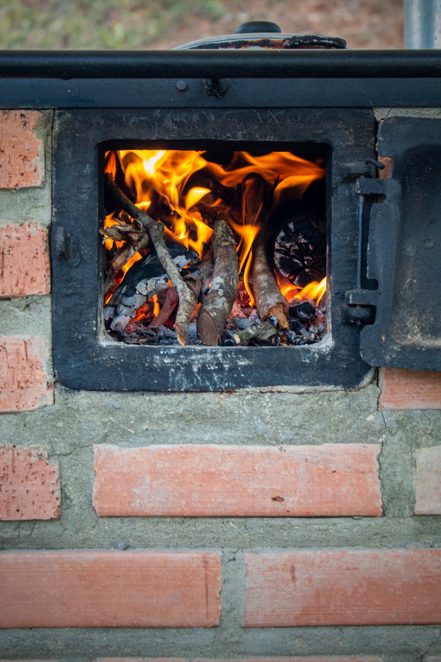 firebox flames inside an offset smoker at dusk