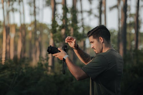 Man Taking Pictures with a Camera in the Forest