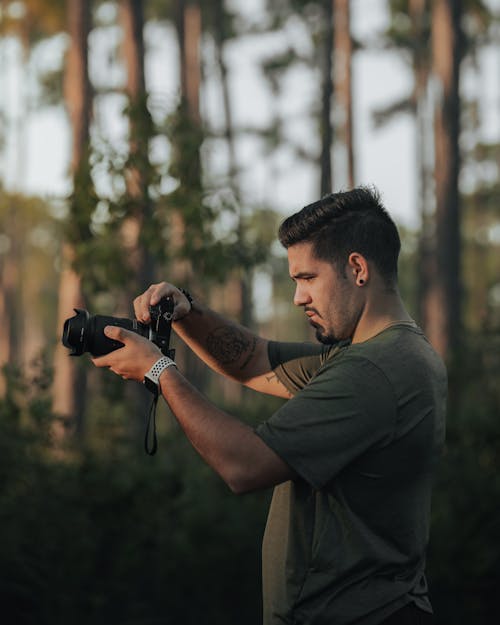 Man Taking Pictures with a Camera in the Forest