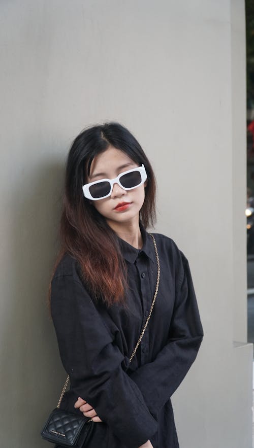 Young Woman Wearing a Fashionable Black Outfit and Sunglasses