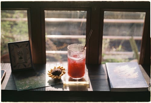 Cocktail with Straw and Book by Windows