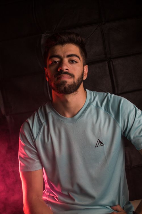 Free Fashion portrait of a man with a beard in a gray t-shirt against a dark background. Stock Photo