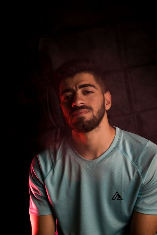 Free A dramatic portrait of a bearded man wearing a t-shirt with creative lighting. Stock Photo