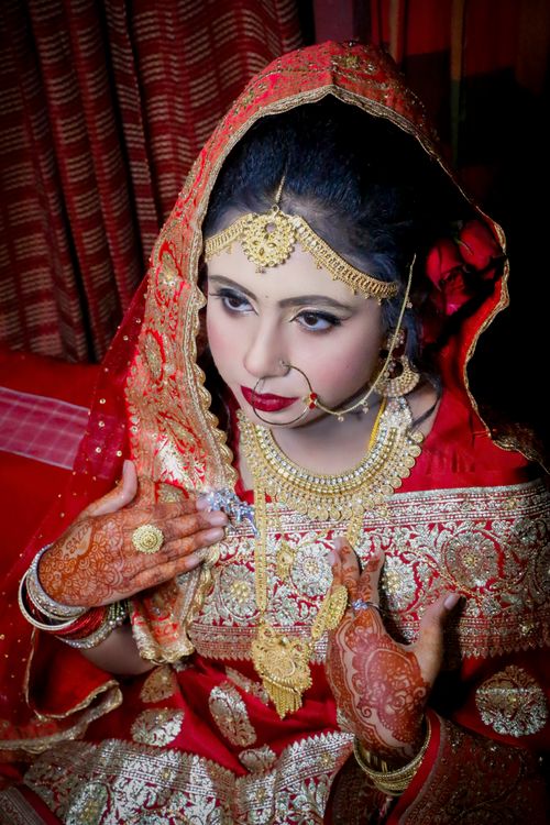 Free Beautiful portrait of an Indian bride in intricate traditional clothing and jewelry. Stock Photo