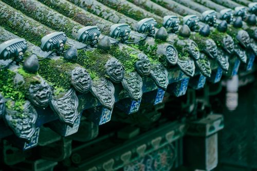 Free Close-up of ornate, moss-covered decorative roof elements on a traditional Chinese temple. Stock Photo