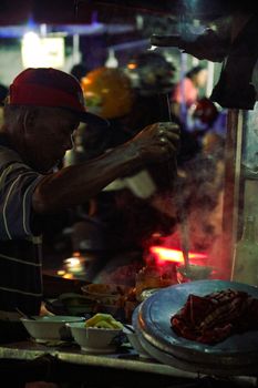 A street food vendor cooking at night in Yogyakarta, showcasing traditional Indonesian cuisine.